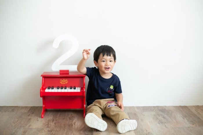 2歳男の子と一緒の家族撮影。親子リンクコーデが素敵です。赤いピアノの小物を気に入ってくれました。