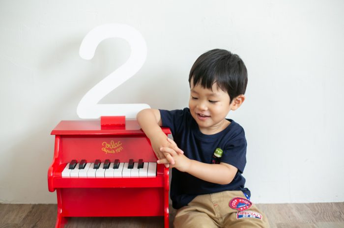 2歳男の子と一緒の家族撮影。親子リンクコーデが素敵です。赤いピアノの小物